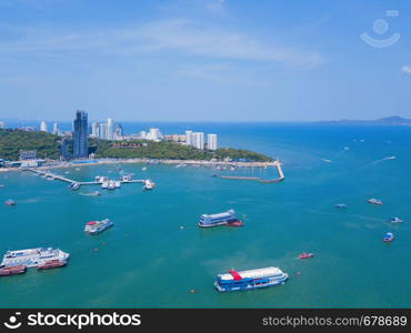 Aerial view of boats in Pattaya sea, beach in summer, and urban city with blue sky for travel background. Chon buri Province, Thailand.