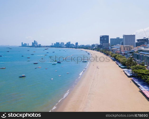 Aerial view of boats in Pattaya sea, beach in summer, and urban city with blue sky for travel background. Chon buri Province, Thailand.