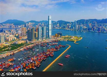 Aerial view of boats in Victoria Harbour, Hong Kong Downtown. Financial district and business centers in technology smart city in Asia. Skyscraper and high-rise buildings at noon with blue sky.