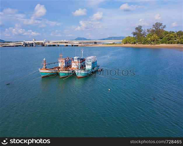 Aerial view of boats with natural forest trees, sand, tropical beach and waves rolling into the shore, Andaman sea, Phuket bay island in summer season, Thailand. Top view