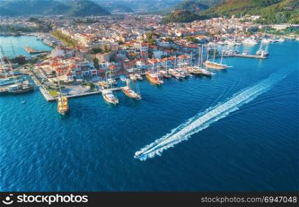 Aerial view of boats, yahts, floating ship and beautiful architecture at sunset in Marmaris, Turkey. Landscape with boats in marina bay, blue sea, city. Top view of harbor with yacht and sailboat. . Aerial view of boats, yahts, floating ship and architecture