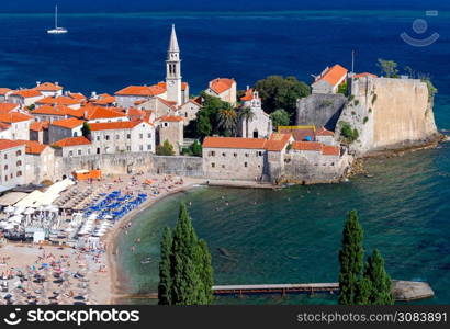 Aerial view of Budva and the city beach on a sunny day.. Aerial view of Budva on a sunny day.