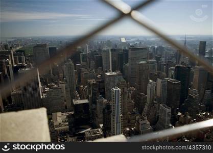 Aerial view of buildings seen through a window grill, New York City, New York State, USA
