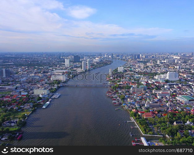 Aerial view of buildings with Chao Phraya River in transportation concept. Bangkok skyline background, Urban city in downtown area at sunset, Thailand.