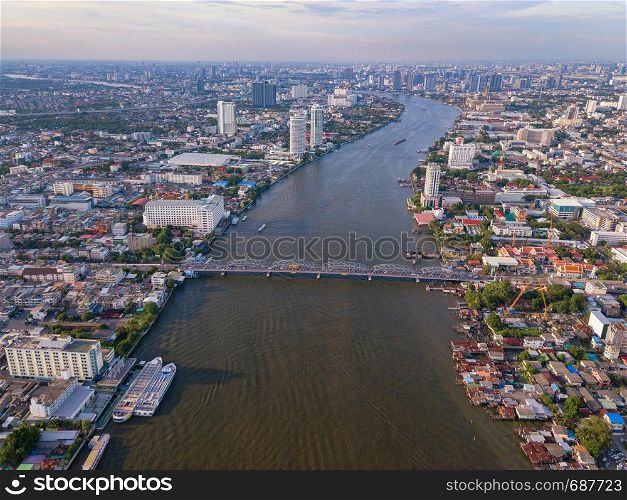 Aerial view of buildings with Chao Phraya River in transportation concept. Bangkok skyline background, Urban city in downtown area at sunset, Thailand.