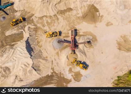 Aerial view of bulldozer pouring sand into truck