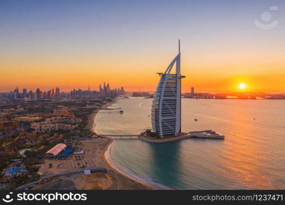 Aerial view of Burj Al Arab Jumeirah Island, Dubai Downtown skyline, United Arab Emirates or UAE. Financial district and business area in smart urban city. Skyscraper and high-rise buildings at sunset