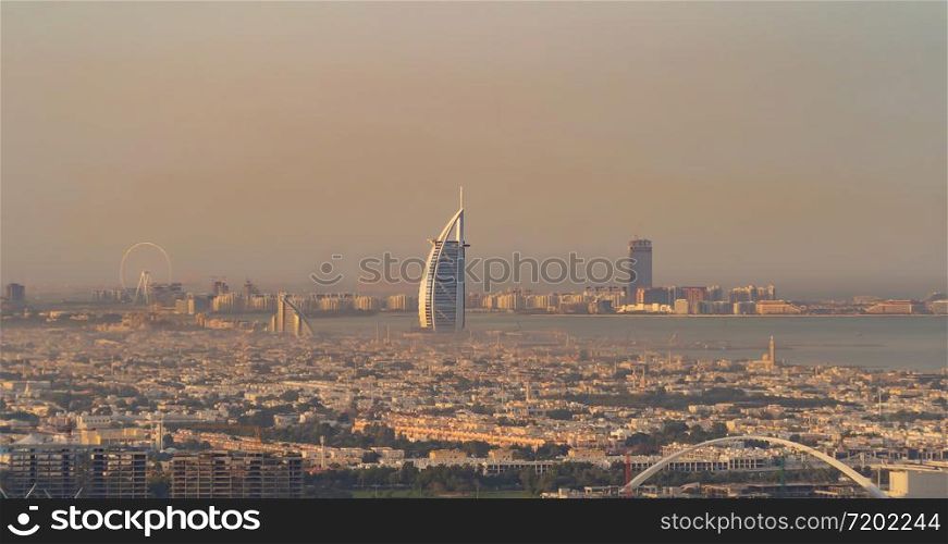 Aerial view of Burj Al Arab Jumeirah Island or boat building, Dubai Downtown skyline, United Arab Emirates or UAE. Financial district in urban city. Skyscrapers at sunset.