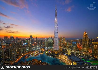 Aerial view of Burj Khalifa in Dubai Downtown skyline and fountain, United Arab Emirates or UAE. Financial district and business area in smart urban city. Skyscraper and high-rise buildings at night.