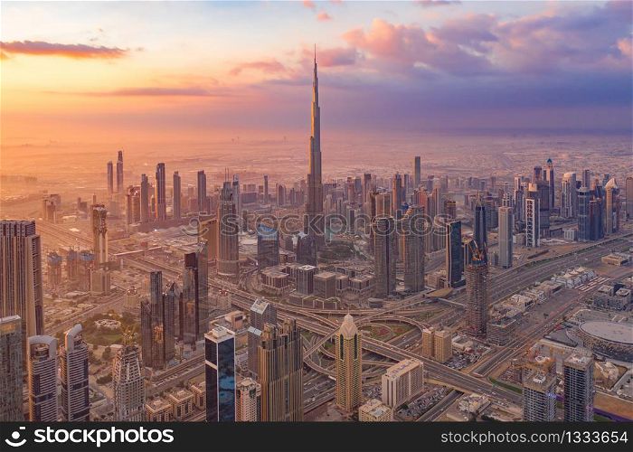 Aerial view of Burj Khalifa in Dubai Downtown skyline and highway, United Arab Emirates or UAE. Financial district and business area in smart urban city. Skyscraper and high-rise buildings at sunset.
