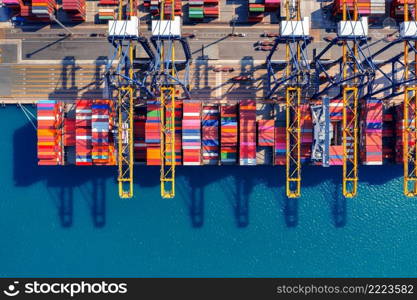 Aerial view of cargo ship and cargo container in harbor.