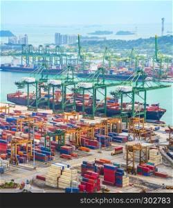 Aerial view of cargo ships in Singapore industrial port harbor by pier with freight cranes and goods containers, seacsape at background