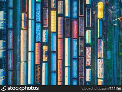 Aerial view of cargo trains. Railway wagons with goods on railroad. Top view of colorful freight train on the railway station. Heavy industry. Industrial conceptual landscape. Transportation. Art. Aerial view of cargo trains. Railway wagons