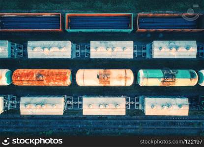 Aerial view of cargo trains. Railway wagons with goods on railroad. Top view of colorful freight train on the railway station. Heavy industry. Industrial conceptual landscape. Transportation. Vintage. Aerial view of cargo trains. Railway wagons