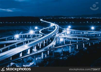 Aerial view of cars driving on complex highway or freeway. Bridge roads or streets in structure of architecture and transportation concept. Top view. Urban city, Taichung at night, Taiwan.
