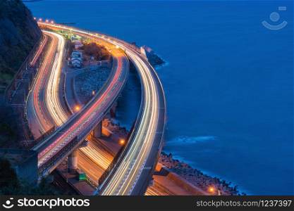 Aerial view of cars driving on highway junctions. Bridge roads shape in connection of architecture concept. Top view. Urban city, Bangkok at night, Shizuoka, Japan.