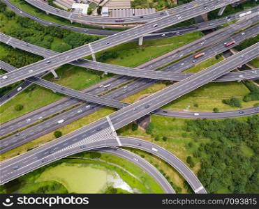 Aerial view of cars driving on highway junctions. Bridge roads with green garden and trees in connection of architecture concept. Top view. Urban city, Taipei, Taiwan.