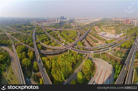 Aerial view of cars on highway junctions. Bridge roads or streets in structure of architecture and transportation concept. Top view. Urban city, Shanghai at noon, China.
