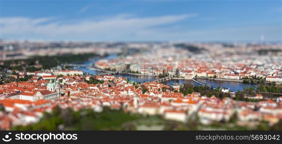 Aerial view of Charles Bridge over Vltava river and Old city from Petrin hill Observation Tower with tilt shift toy effect shallow depth of field. Prague, Czech Republic