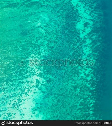 Aerial view of clear blue turquoise seawater, Andaman sea in Phuket island in summer season, Thailand. Water in ocean material pattern texture wallpaper background.