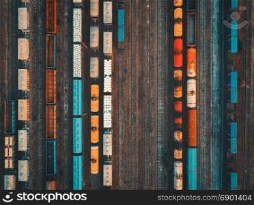 Aerial view of colorful freight trains. Aerial view of colorful freight trains on the railway station. Cargo trains close-up. Wagons with goods on railroad. Heavy industry. Industrial conceptual scene with trains. Top view. Vintage style