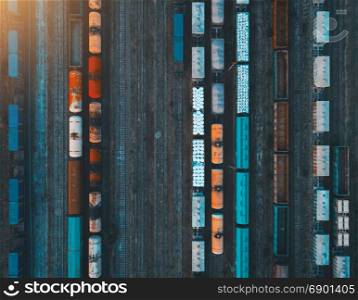 Aerial view of colorful freight trains. Aerial view of colorful freight trains on the railway station. Cargo trains close-up. Wagons with goods on railroad. Heavy industry. Industrial conceptual scene with trains. Top view. Vintage style