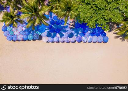 Aerial view of colorful umbrellas, beach, and turquoise sea with space for text. Sunny summer day for travel or holiday background in Pattaya, Chon Buri province, Thailand. Top view