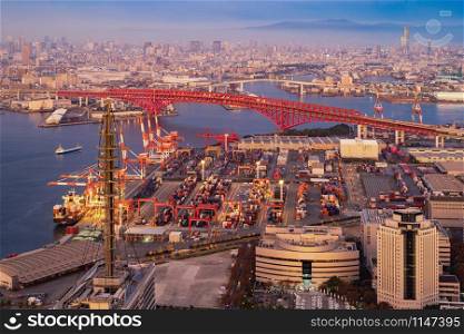 Aerial view of container cargo ship in the export and import business and logistics international goods in urban city. Shipping to the harbor by crane in Osaka Harbour, Japan