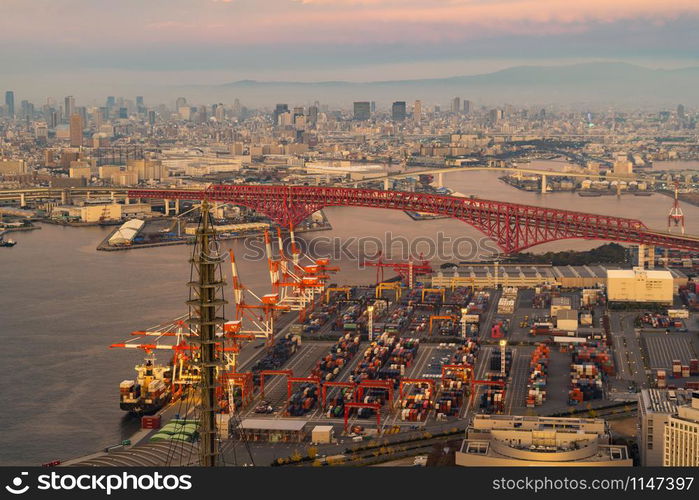 Aerial view of container cargo ship in the export and import business and logistics international goods in urban city. Shipping to the harbor by crane in Osaka Harbour, Japan