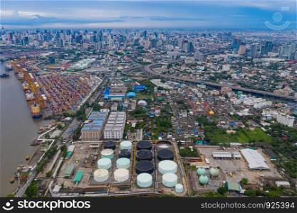 Aerial view of container cargo ship in the export, import business, logistics and transportation. International goods in urban city. Shipping to the harbor by crane in Bangkok City, Thailand.