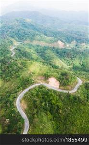 Aerial view of curve mountains road near Thailand-Myanmar border. Mountains road surrounded by green forest. Development, transportation concepts.
