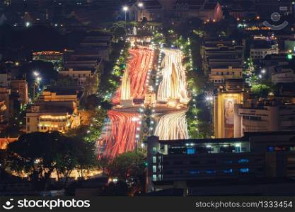 Aerial view of Democracy monument with car light trails on road in Bangkok Downtown, urban city at night, Thailand. Landmark architecture landscape background.