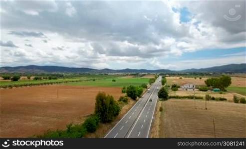 Aerial view of driving cargo by highway in the rural countryside . Aerial view on the mountains in Tuscany, Italy