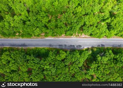 Aerial view of drone to road through green forest