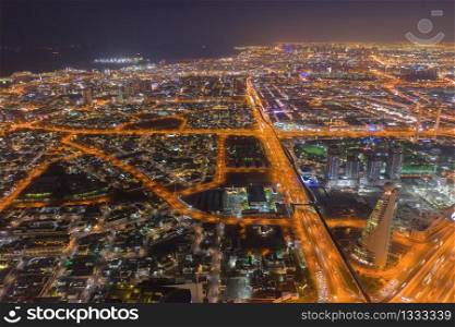 Aerial view of Dubai Downtown, highway roads or street in United Arab Emirates or UAE. Financial district and business area in smart urban city. Skyscraper and high-rise buildings at night.