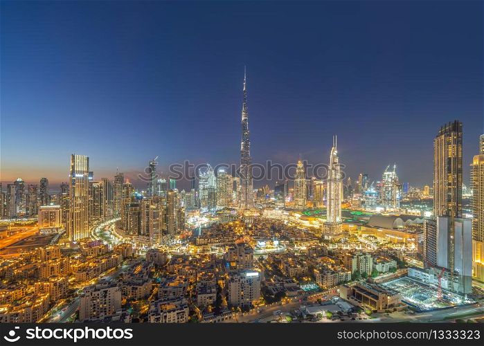 Aerial view of Dubai Downtown skyline, highway roads or street in United Arab Emirates or UAE. Financial district and business area in smart urban city. Skyscraper and high-rise buildings at sunset.