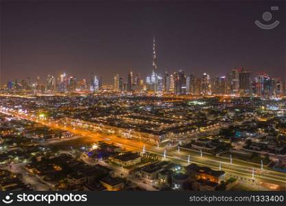 Aerial view of Dubai Downtown skyline, highway roads or street in United Arab Emirates or UAE. Financial district and business area in smart urban city. Skyscraper and high-rise buildings at night.