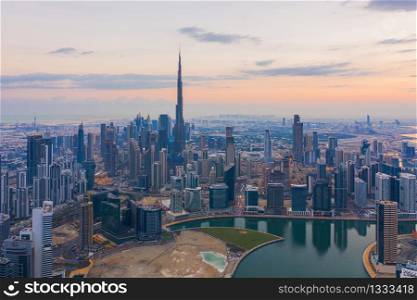Aerial view of Dubai Downtown skyline, highway roads or street in United Arab Emirates or UAE. Financial district and business area in smart urban city. Skyscraper and high-rise buildings at sunset.