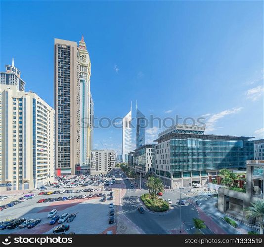 Aerial view of Dubai Downtown skyline with parking in United Arab Emirates or UAE. Financial district and business area in smart urban city. Skyscraper and high-rise buildings with blue sky at noon.