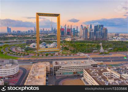 Aerial view of Dubai Frame, Downtown skyline, United Arab Emirates or UAE. Financial district and business area in smart urban city. Skyscraper and high-rise buildings at sunset.