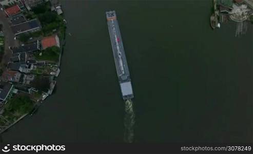 Aerial view of empty barge sailing along the river in the town of Netherlands