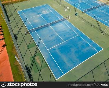 Aerial view of empty blue hard tennis court on a sunny day