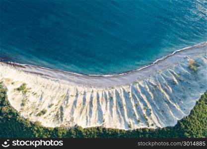Aerial view of empty seashore. Curved line of surf.