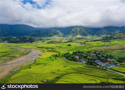 Aerial view of Fansipan mountain hills valley on summer with paddy rice terraces, green agricultural fields in rural area in travel trip and holidays vacation concept, Sapa, Vietnam. Nature landscape.