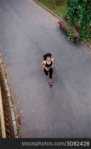 Aerial view of female athlete running on a road