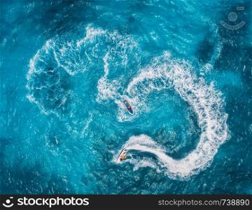 Aerial view of floating water scooter in blue water at sunny day in summer. Holiday in Indian ocean, Zanzibar, Africa. Top view of jet ski in motion. Tropical seascape with moving motorboat. Boats