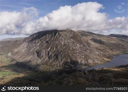 Aerial view of flying drone Epic early Autumn Fall landscape image of view along Ogwen vslley in Snowdonia National Park with dramatic sky and mountains