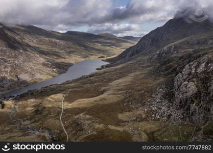 Aerial view of flying drone Epic early Autumn Fall landscape image of view along Ogwen vslley in Snowdonia National Park with dramatic sky and mountains