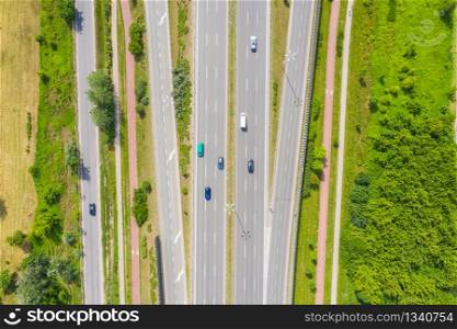Aerial view of green summer forest with a road.
