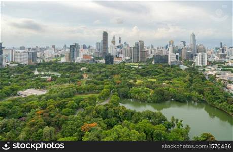 Aerial view of green trees in Lumpini Park, Sathorn district, Bangkok Downtown Skyline. Thailand. Financial district and business center in smart urban city in Asia. Skyscraper buildings